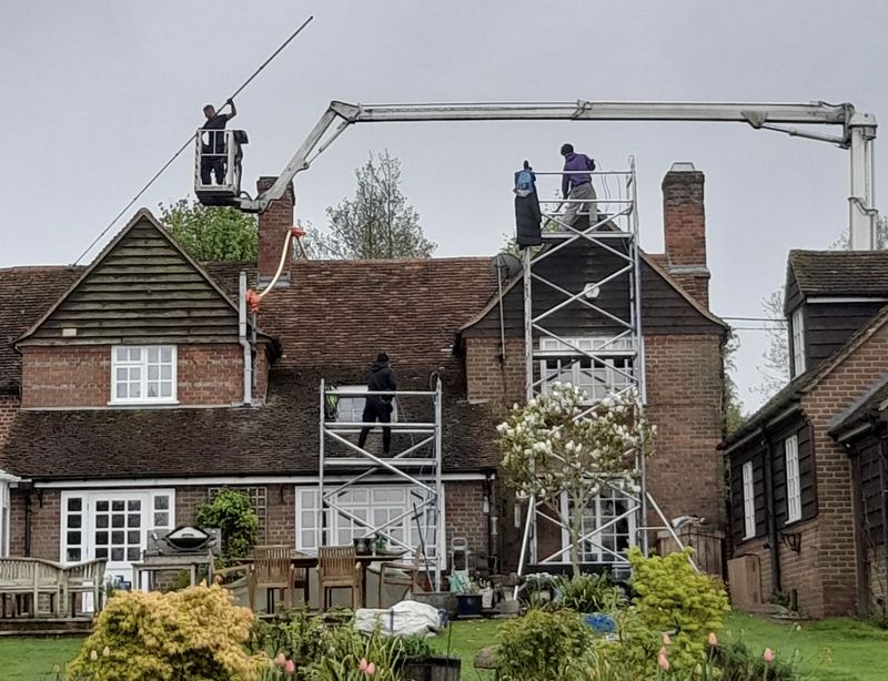 The Moss Cleaners using cherry picker and scaffolding to clean roof safely and professionally in Witley, Surrey